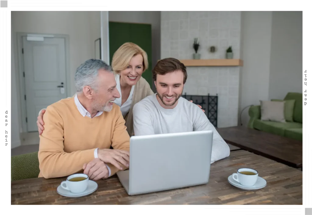 Two parents and their adult son gathered around a laptop at the kitchen table, smiling together — capturing the relief and clarity a family feels when they finally have everything organized and documented in one place.